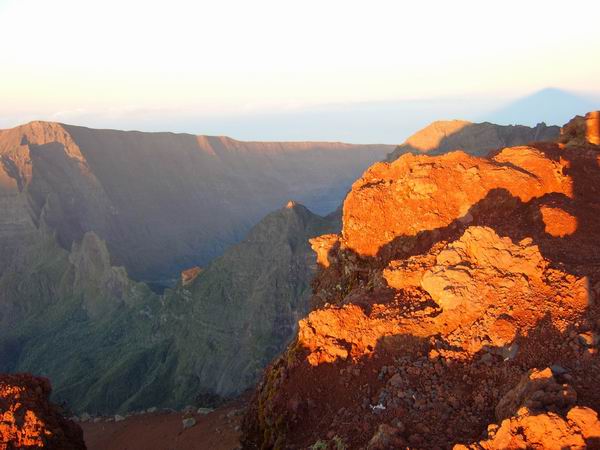 Les premiers rayons du soleil font ressortir le rouge de la pierre volcanique