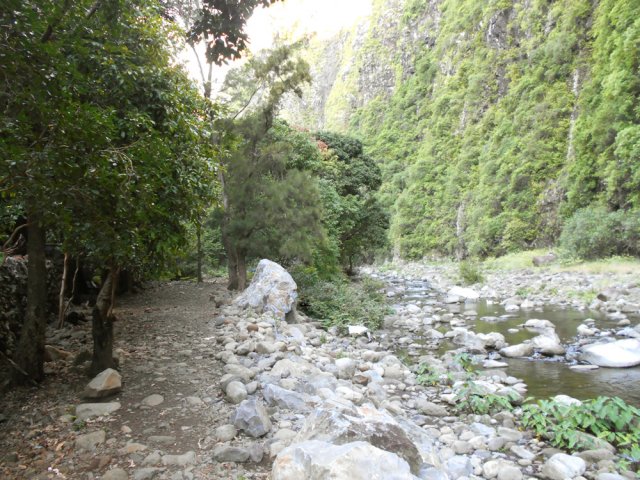 Près des habitations modestes, le sentier est plus large