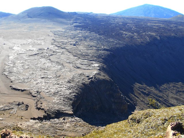 Un sentier file vers Grand Pays par une longue descente