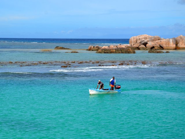 Des pêcheurs vus du bateau avant d'arriver au port