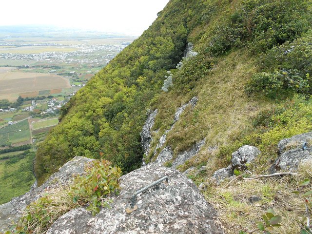 Vers la gauche, le sentier s'arrête à ces plots en fer fichés dans le roc