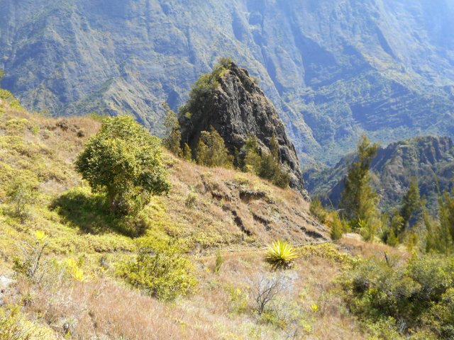 Le sentier, bordé de tuyaux, se rapproche d'une dent rocheuse