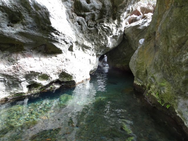 Ici, le cours d'eau poursuit sous d'énormes blocs de roches