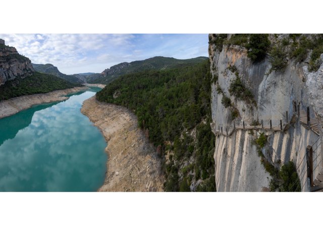 L'escalier, accroché à la falaise, domine le lac