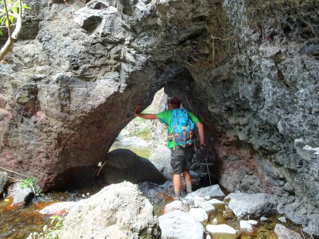 L'arche basaltique se contourne par un très étroit passage entre les rochers