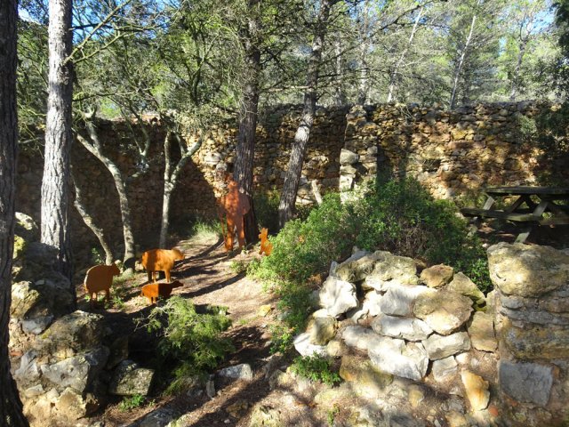 Un berger stylisé et ses moutons dans un ancien parc de bergerie